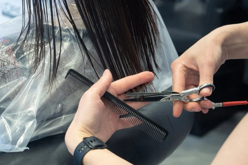 coiffeuse qui coupe des cheveux longs