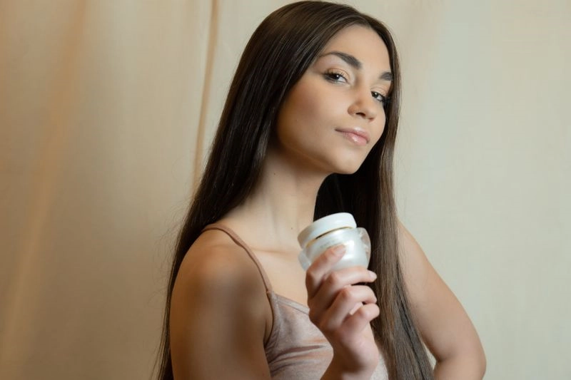 femme avec sa crème de jour ou de nuit